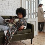 woman laying on sofa, man in kitchen