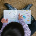 An overhead shot of a boy reading a picture book.