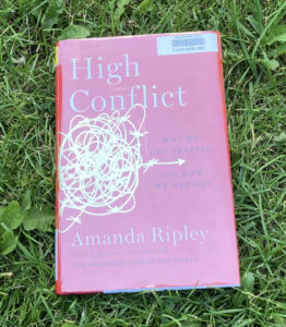 High Conflict hardcover book on grass
