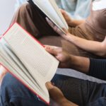 man reading book beside woman reading book