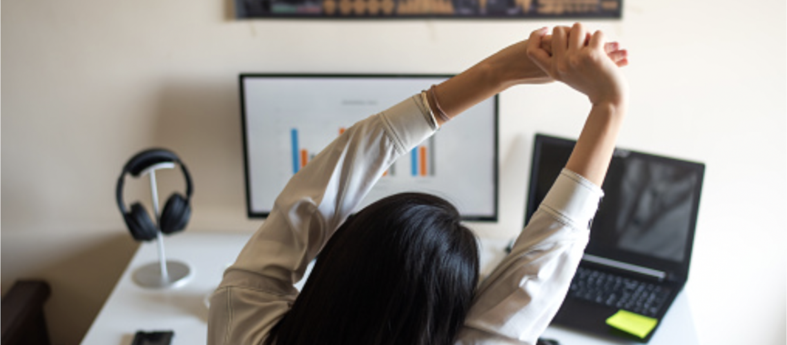 woman stretches while working at desk